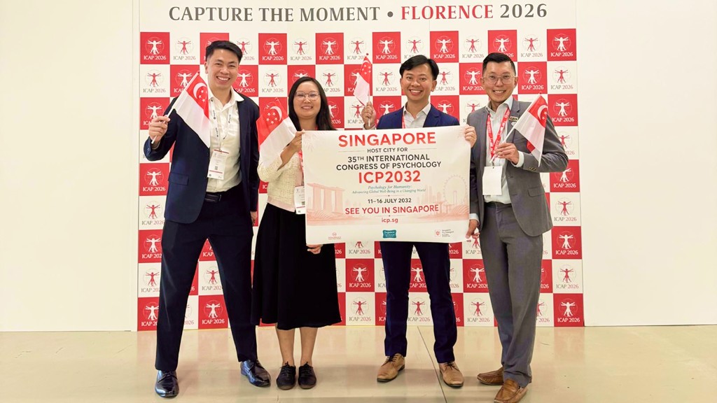 Team Singapore with ICP 2032 host city banner at ICAP 2026 in Florence